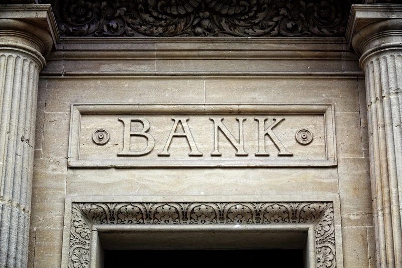 Capital letters BANK carved into a stone masonry